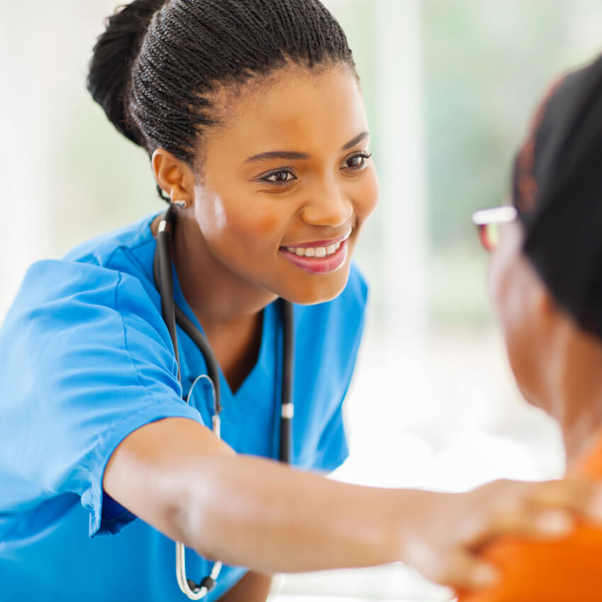 Smiling nurse with hand on shoulder of a patient